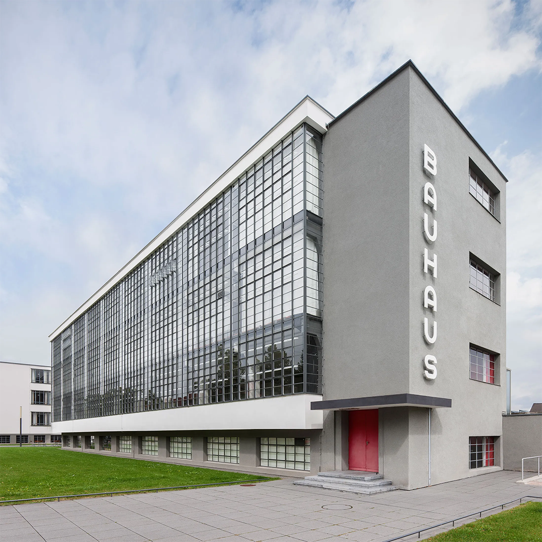 Immagine della scuola Bauhaus, icona dell'architettura modernista, caratterizzata da linee essenziali e vetrate ampie che riflettono la filosofia del design funzionale e innovativo.